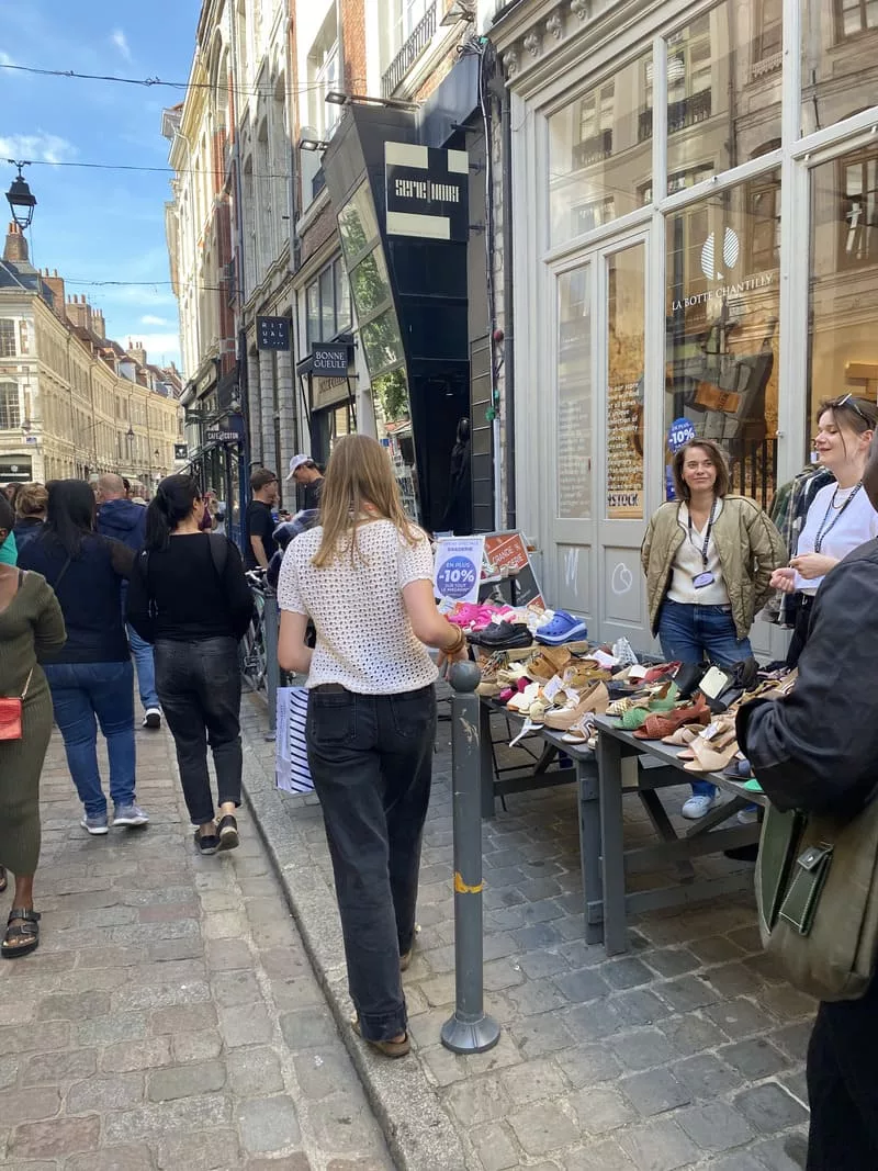 Residents selling shoes and personal items on a table outside a shop on Rue Lepelletier, Vieux-Lille, during the Braderie de Lille