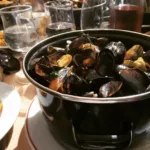 Pot of fresh moules-frites served on a sunny terrace table during the Braderie de Lille