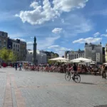 Grand Place in Lille with cafés, terraces and the Goddess Column on a sunny afternoon.