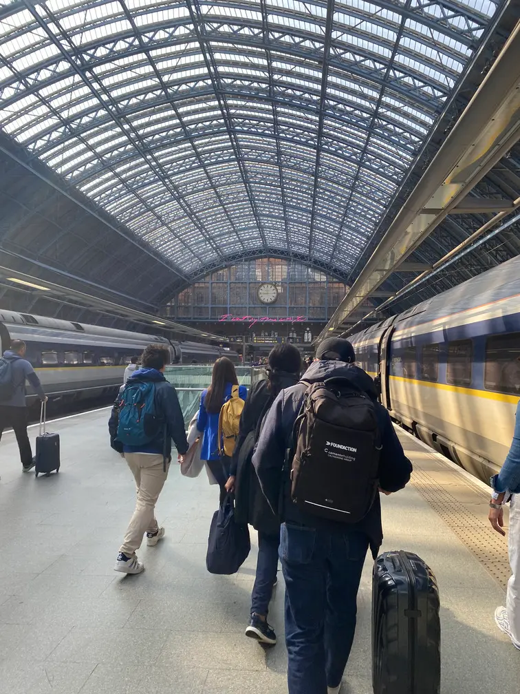 Travellers walking towards Eurostar trains beneath the Victorian roof of London St Pancras International.