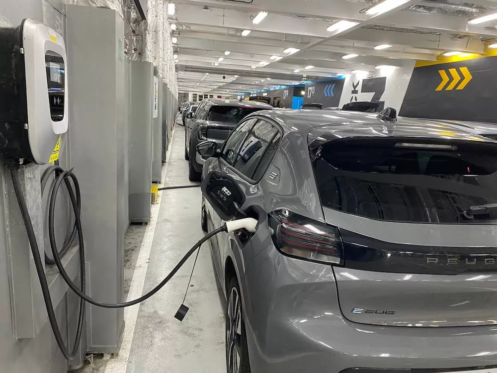 Peugeot e-208 plugged into an onboard charger on the car deck of a P&O ferry between Dover and Calais