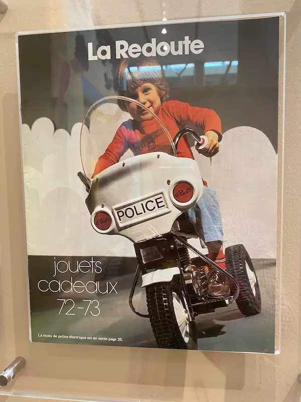 Vintage La Redoute toys and gifts catalogue from 1972–73, displayed in an exhibition about the retailer's history.
